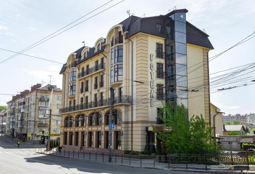 een groot geel gebouw met een zwart dak bij Avalon Palace in Ternopilʼ