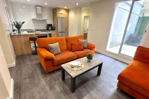 een woonkamer met een oranje bank en een tafel bij Casa nueva en el Centro in Santander