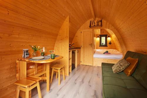 een kamer met een tafel en een bed in een hut bij KampinaStaete, hippe cottages midden in natuurgebied de Kampina Oisterwijk in Oisterwijk