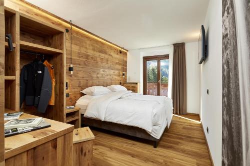 um quarto com uma cama e uma parede de madeira em Hotel Garni dello Sportivo em Madonna di Campiglio