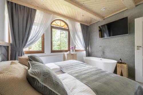 una camera con letto, vasca e TV di Apartamenty Villowe - Zakopane Centrum a Zakopane