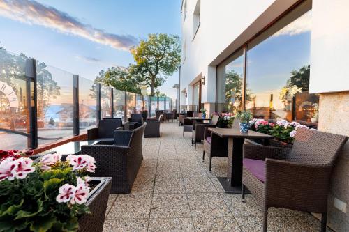 a row of chairs and tables in a restaurant with flowers at Dom Wczasowy Plaża in Rewal