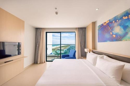 um quarto de hotel com uma cama e uma grande janela em ARTRA resort- near Cam Ranh Airport em Cam Ranh