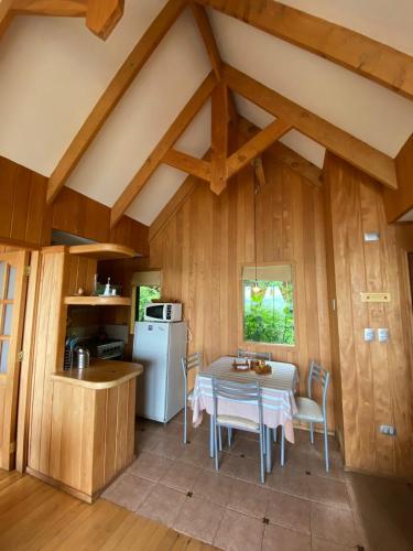 cocina y comedor con mesa y nevera en Cabañas Bahia Celeste, Puerto Varas, en Puerto Varas