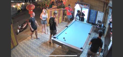 Un groupe de personnes autour d'un billard dans l'établissement Luang Prabang Hostel, à Luang Prabang