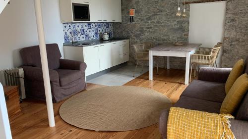 een woonkamer met 2 stoelen en een tafel bij Quinta das Vinhas in Calheta