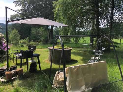 un giardino con ombrellone e tavolo e sedie di Le refuge de Kila a Waimes