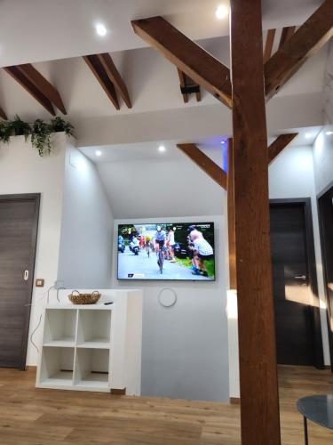 uma sala de estar com uma televisão de ecrã plano na parede em Vila Rajska ptica em Bled