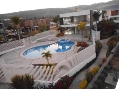 Hermosa Casa en Orilla del lago -Zona de villedos- في San Cristóbal Zapotitlán: اطلالة علوية على مسبح به نخيل ومبنى