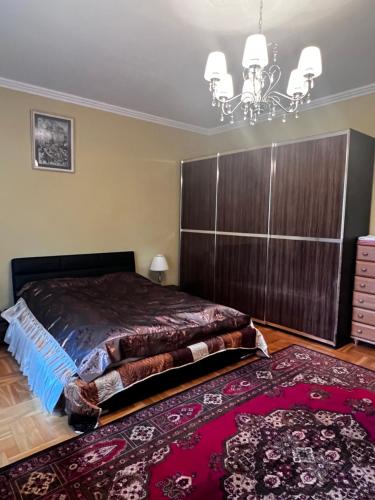 - une chambre avec un grand lit et un lustre dans l'établissement Spacious rooms in peaceful Jelgava area, à Jelgava