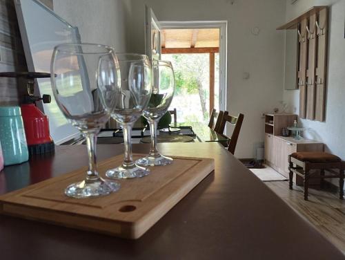 tre bicchieri da vino seduti su un vassoio di legno su un tavolo di Apartment Serenity a Ohrid