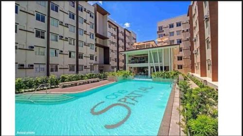 une piscine en face d'un bâtiment dans l'établissement One spatial condominium by filinvest, à Iloilo