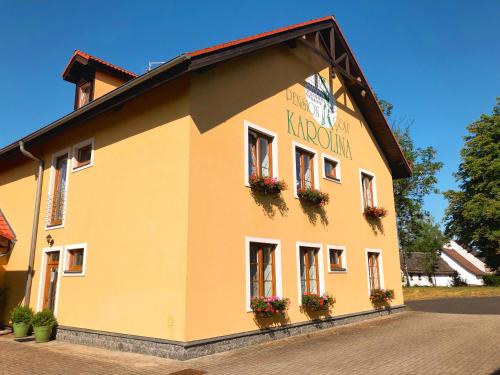 um edifício amarelo com flores nas janelas em Golf Hotel Karolina em Karlovy Vary