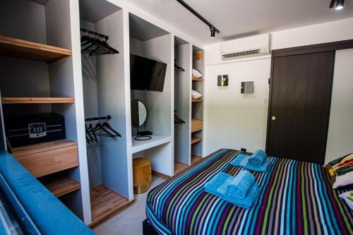 um quarto com uma cama, uma televisão e prateleiras em Appartement de caractère avec Jacuzzi em Fréjus