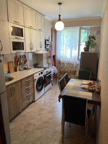 uma cozinha com uma mesa com cadeiras e uma sala de jantar em Apartment Erekle em Borjomi