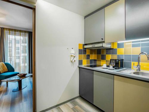 a kitchen with a sink and a counter top at Aparthotel Adagio Köln City in Cologne