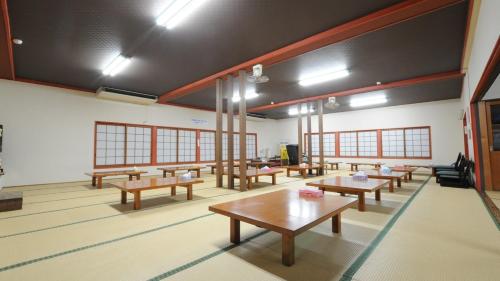 una classe con panche e tavoli in una stanza di Yourou Onsen Honkan a Onomichi