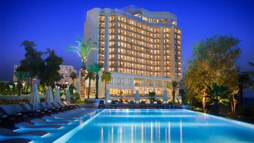 un hôtel avec une piscine en face d'un bâtiment dans l'établissement Akra Antalya, à Antalya