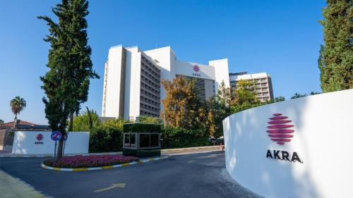 un bâtiment avec un panneau en face d'une rue dans l'établissement Akra Antalya, à Antalya