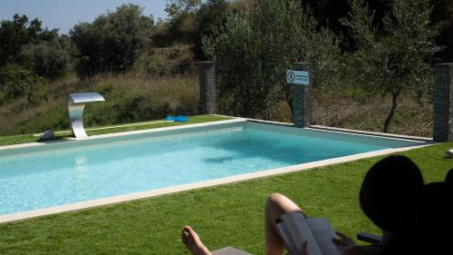 un grupo de personas sentadas junto a una piscina en Aires da Serra Hotel, en Torres Novas