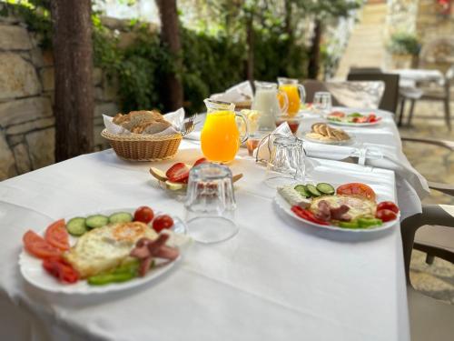 un tavolo con piatti di cibo e bicchieri di succo d'arancia di Arial Trinity Suites a Vlorë