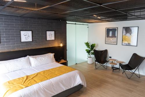 um quarto com uma cama grande e 2 cadeiras em FULTON Business Luxury HOTEL em Guadalajara