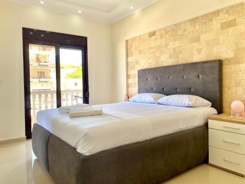 a bedroom with a large bed with a brick wall at Fimi Apartments in Ulcinj