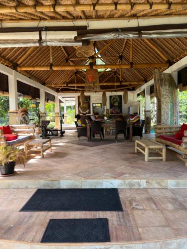 a large living room with wooden tables and chairs at The Papalagi Resort in Gili Gede