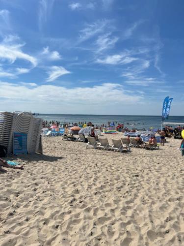 um grupo de pessoas sentadas numa praia em Villa Nadzieja em Międzyzdroje