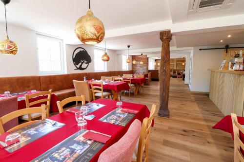 a dining room with red tables and chairs at Black Forest Hotel Kappel-Grafenhausen in Kappel-Grafenhausen