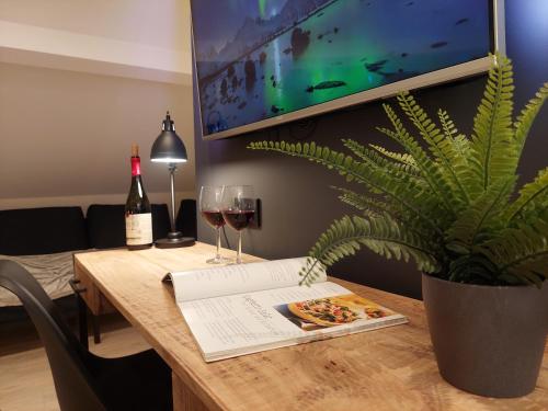 uma mesa com dois copos de vinho e uma planta em Viator Holidayhome em Tongeren