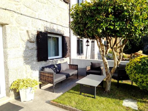 une terrasse avec un canapé, une table et un arbre dans l'établissement Casa do Chico, à Vieira do Minho