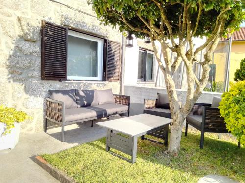 un patio avec des chaises, une table et un arbre dans l'établissement Casa do Chico, à Vieira do Minho