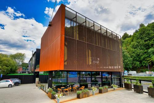 un bâtiment avec des tables et des chaises dans un parking dans l'établissement SINATRA CIGAR HOUSE, à Banská Bystrica