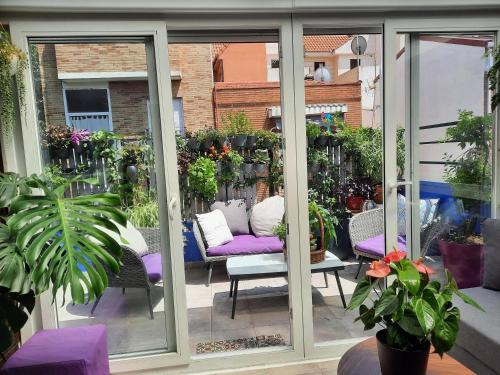 een patio met een paarse bank en veel planten bij Loft con jardin in Madrid