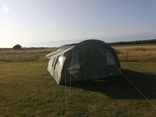 カイユー・シュル・メールにあるtente en baie de somme chez l habitantの野原の黒銀テント