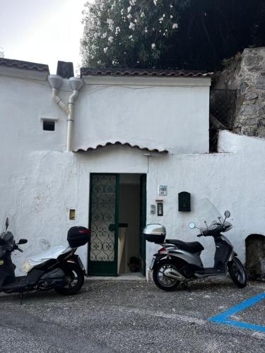 deux motocycles garés devant un immeuble avec porte dans l'établissement Casa Angelica, à Ravello