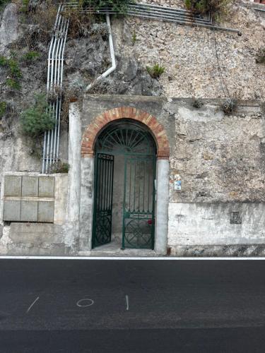 une porte verte sur le côté d'un bâtiment en pierre dans l'établissement Casa Angelica, à Ravello