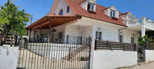 une maison blanche avec un portail et une clôture dans l'établissement Three Artists Cottage, à Pórto Ráfti