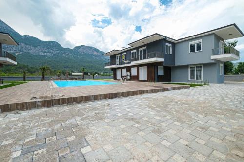 a large house with a swimming pool in front of it at Palmiye Apart Hotel in Antalya