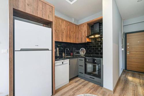 a kitchen with a white refrigerator and wooden cabinets at Palmiye Apart Hotel in Antalya