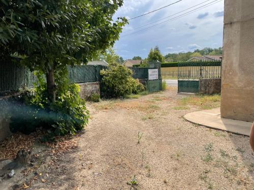 un patio con una valla y un árbol en Le Clos des Cadots - Chambre, en Chaintré