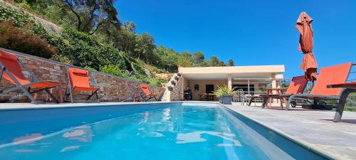 - une piscine avec des chaises et une maison dans l'établissement Les Hauts du Peireguier, à La Motte