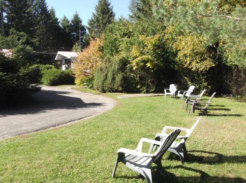 una fila di panche bianche sedute nell'erba di Auberge Mountain View Inn a Mont-Tremblant