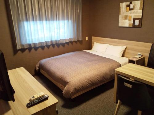 Hotel Route-Inn Nishinasuno-2 في ناسوشيوبارا: غرفه فندقيه بسرير ونافذه