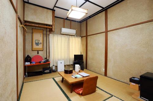 een woonkamer met een tafel en een kamer met een kamer bij Hinode Ryokan in Ise