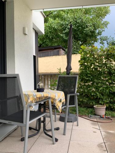 uma mesa e cadeiras e um guarda-sol num pátio em Wohlfühl-Apartment em Ettlingen