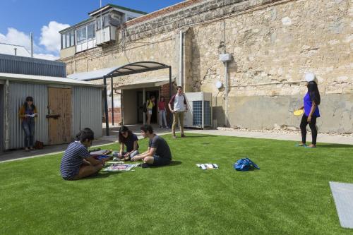 Un groupe de personnes assises sur l'herbe dans l'établissement YHA Fremantle Prison, à Fremantle