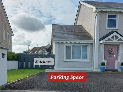 een huis met een parkeerbord op de oprit bij Grá na Farraige in Enniscrone