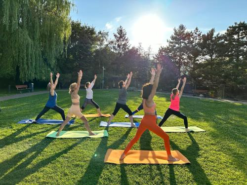 eine Gruppe von Leuten, die eine Yoga-Pose im Gras machen in der Unterkunft Eurohotel Swarzędz in Swarzędz